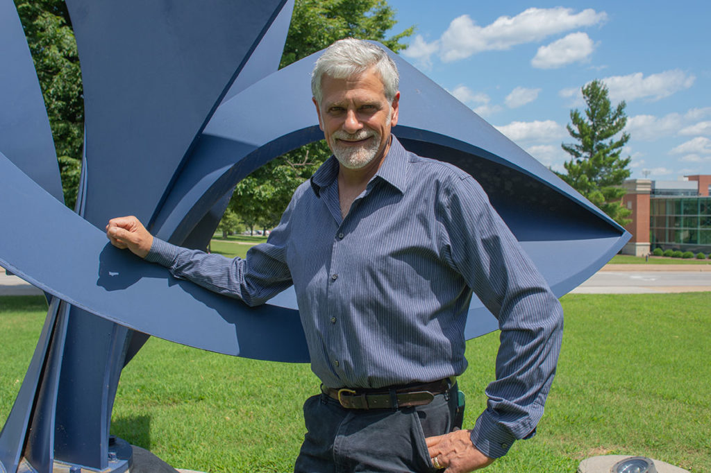 John Medwedeff next to his metal sculpture