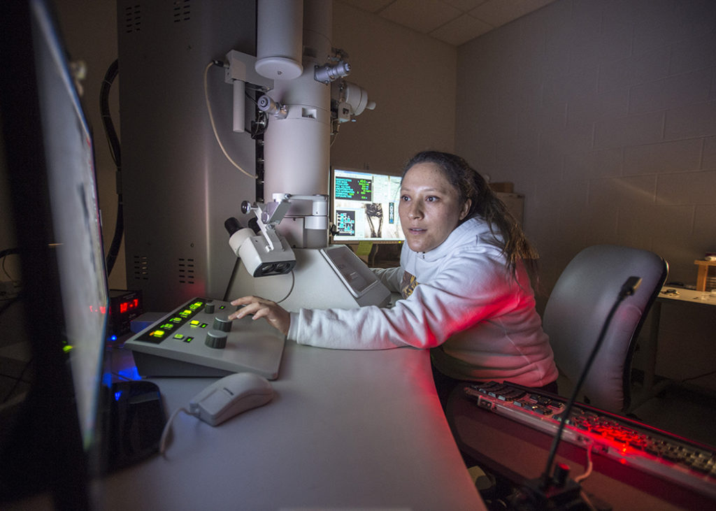 Student works on transmission electron microscope.
