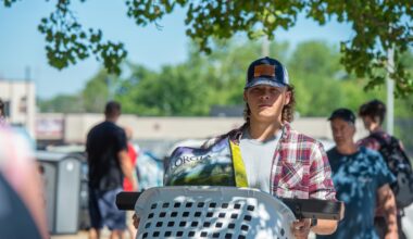 SIU student carrying a laundry basket full of belongings moving into the residence hall (dorm)