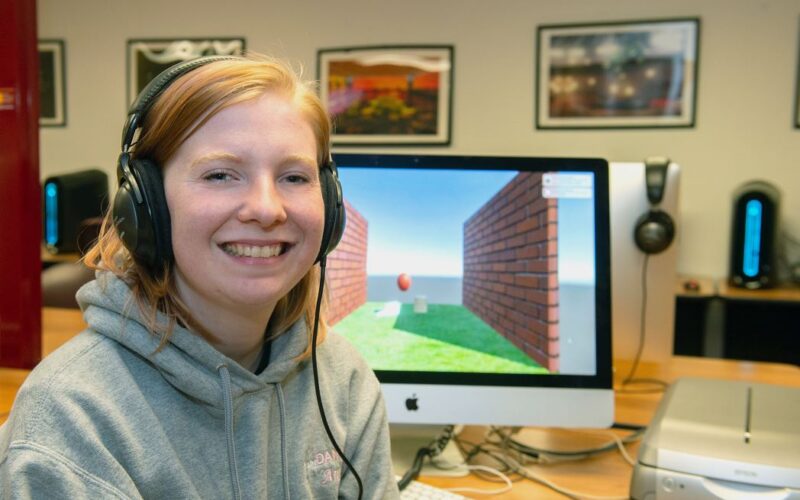 Anna Hainline, junior Animation student sitting in front of a computer that she is using for animation.