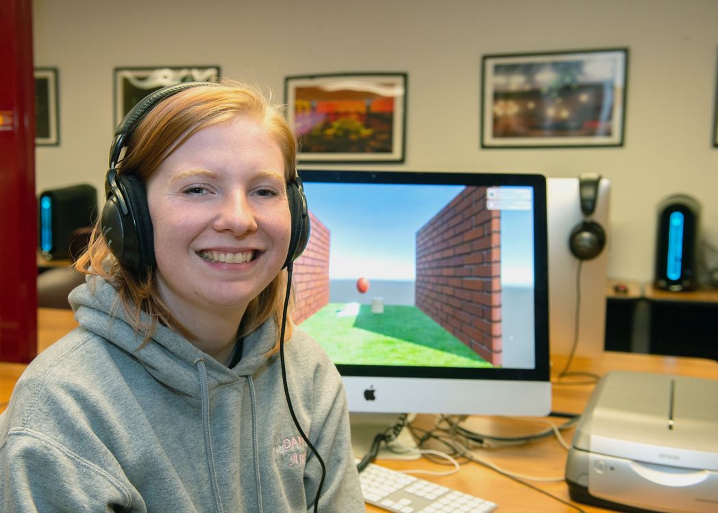 Anna Hainline, junior Animation student sitting in front of a computer that she is using for animation. 