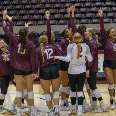 saluki volleyball team cheering after a game