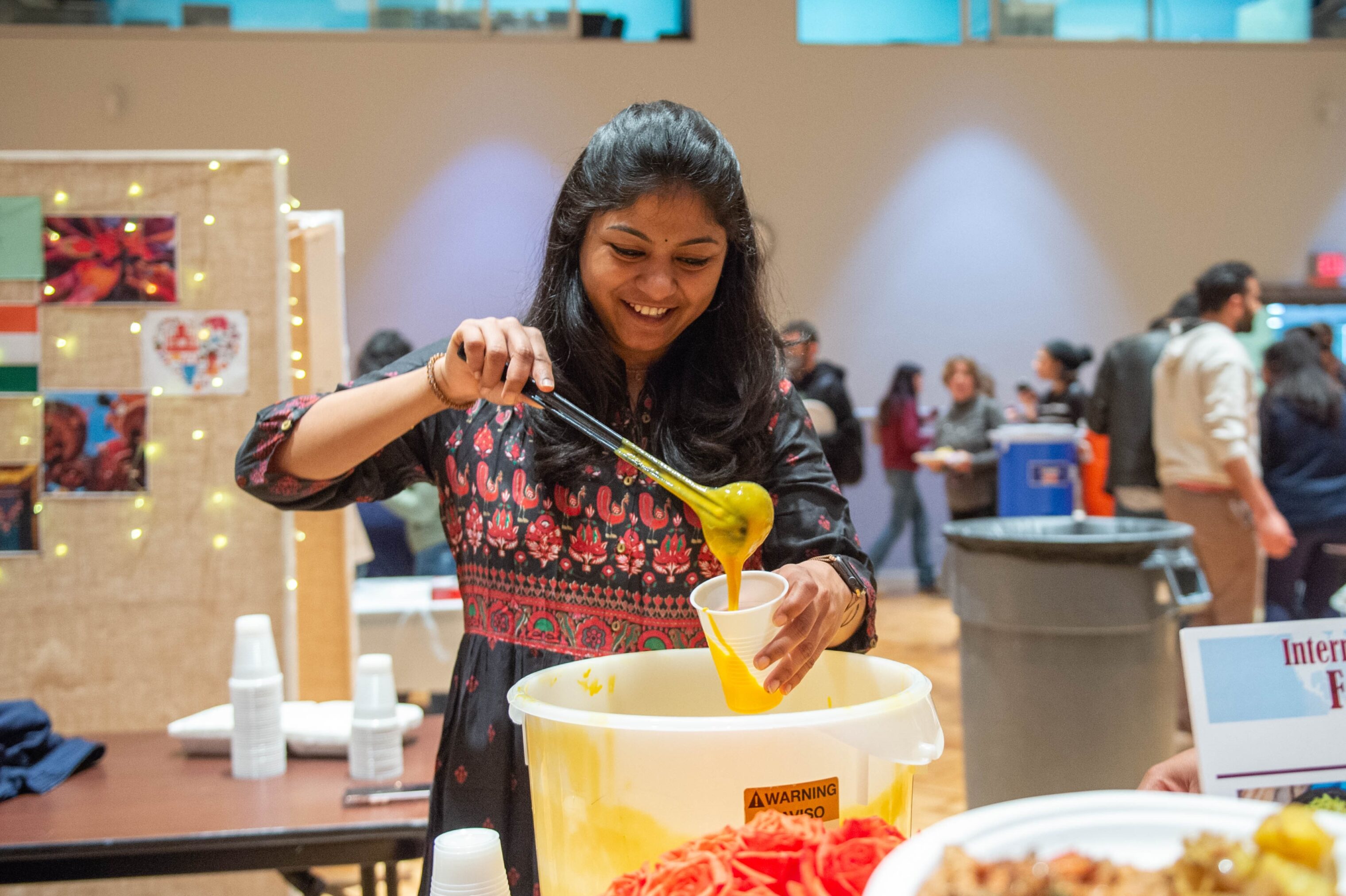 a student serving up a taste of indian spice at the International Food Fest