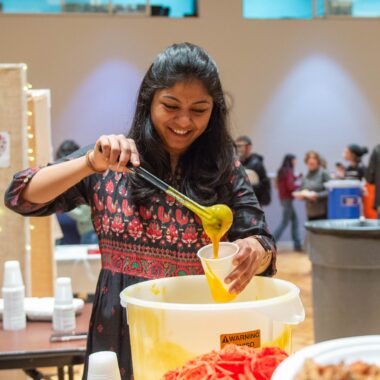 Indian student serving food at the International Food Fest.