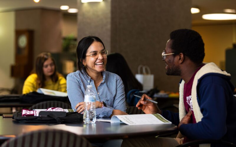 students talking to each other while studying