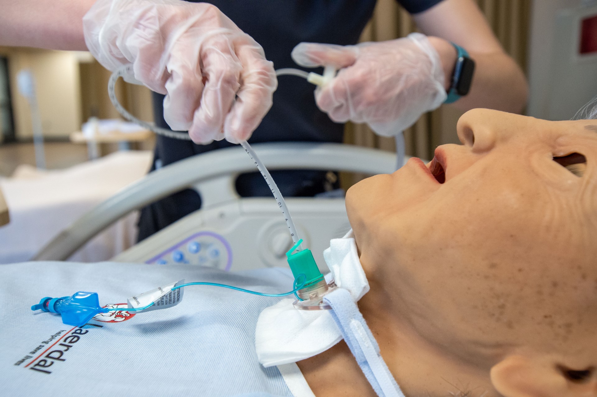 Students learn nursing techniques on a doll. 
