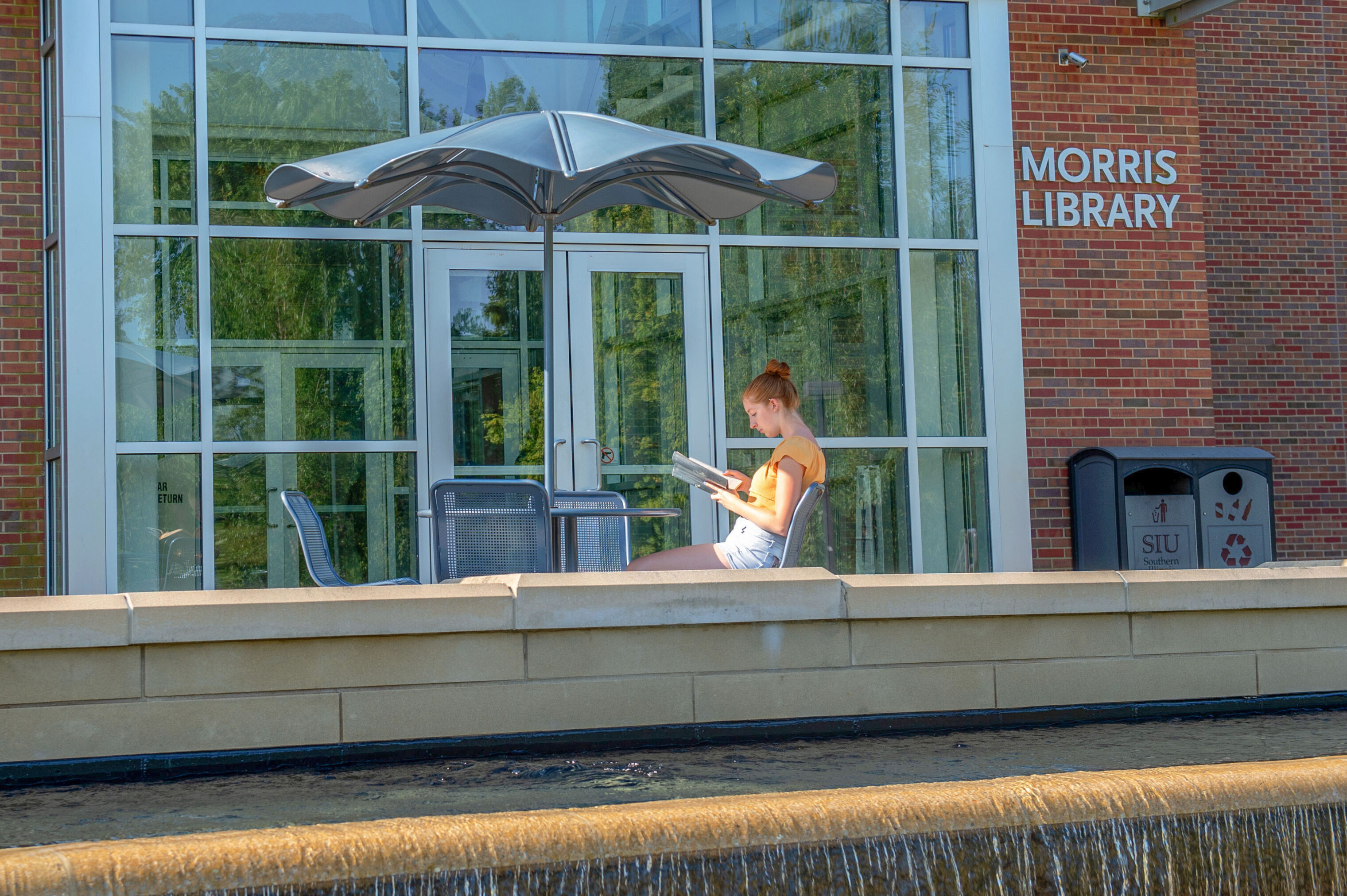 Student reading outside of Morris Library. library lovers month