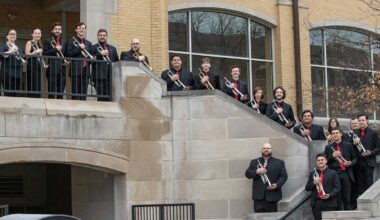 Musicians standing on stairs, holding trumpets.