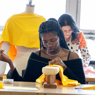A student is sewing clothes.