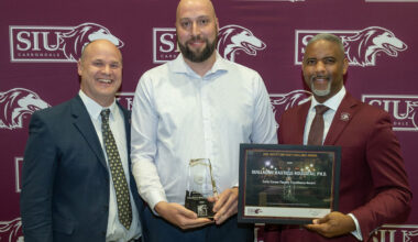 Three men at an award presentation.