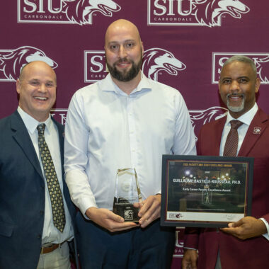 Three men at an award presentation.