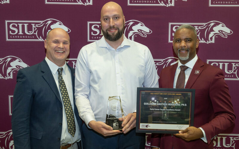 Three men at an award presentation.