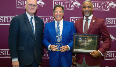 Robert Hahn (center) receives his Excellence Award from Joddy Murray, dean of the College of Liberal Arts (left) and Chancellor Austin Lane.