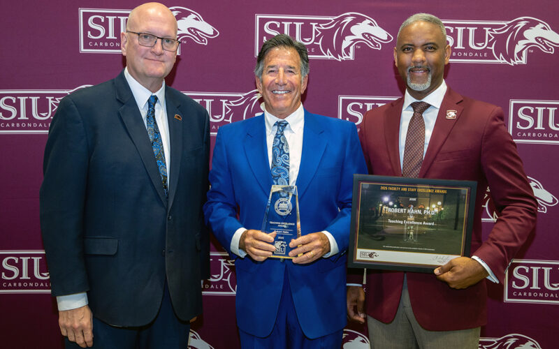 Robert Hahn (center) receives his Excellence Award from Joddy Murray, dean of the College of Liberal Arts (left) and Chancellor Austin Lane.