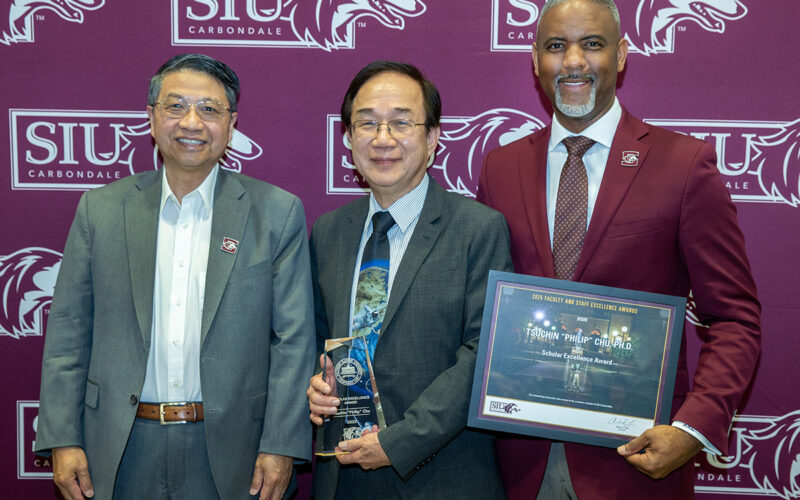 Three men pose for a picture.