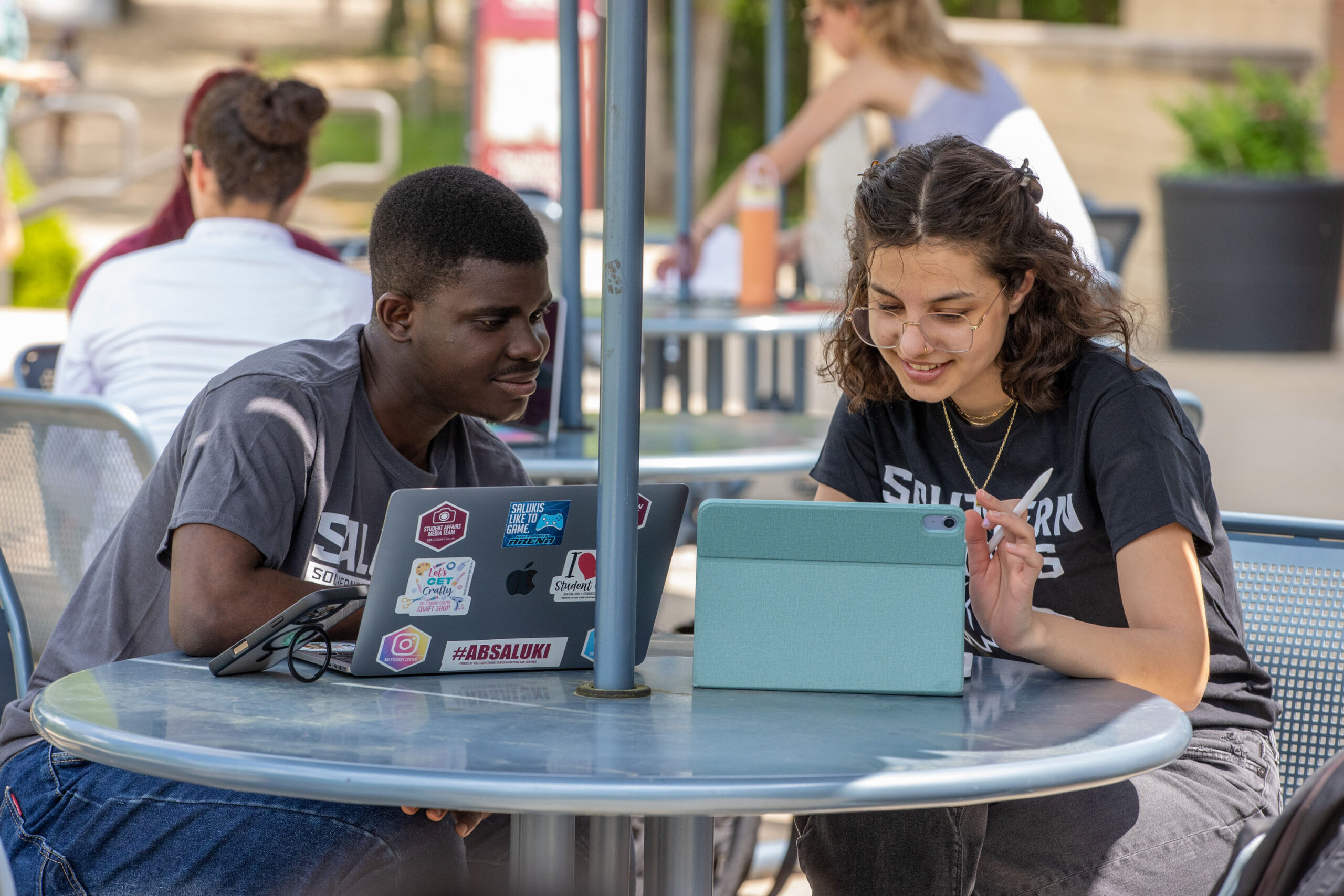 Students on Campus looking at laptops together