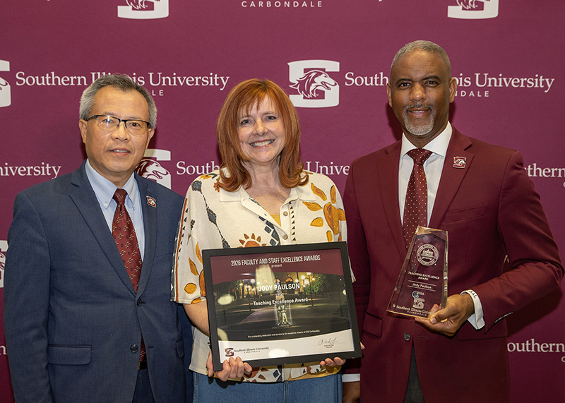 Jody Paulson receives the 2026 Teaching Excellence Award for tenured and tenure-track faculty. She is pictured with Hong Cheng and Chancellor Austin Lane.