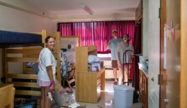 students with boxes in residence hall room