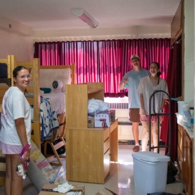students with boxes in residence hall room