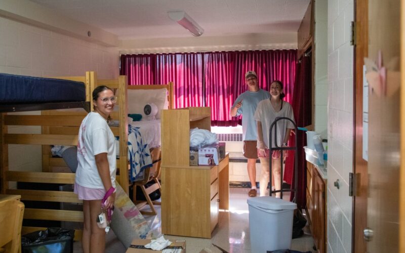students with boxes in residence hall room