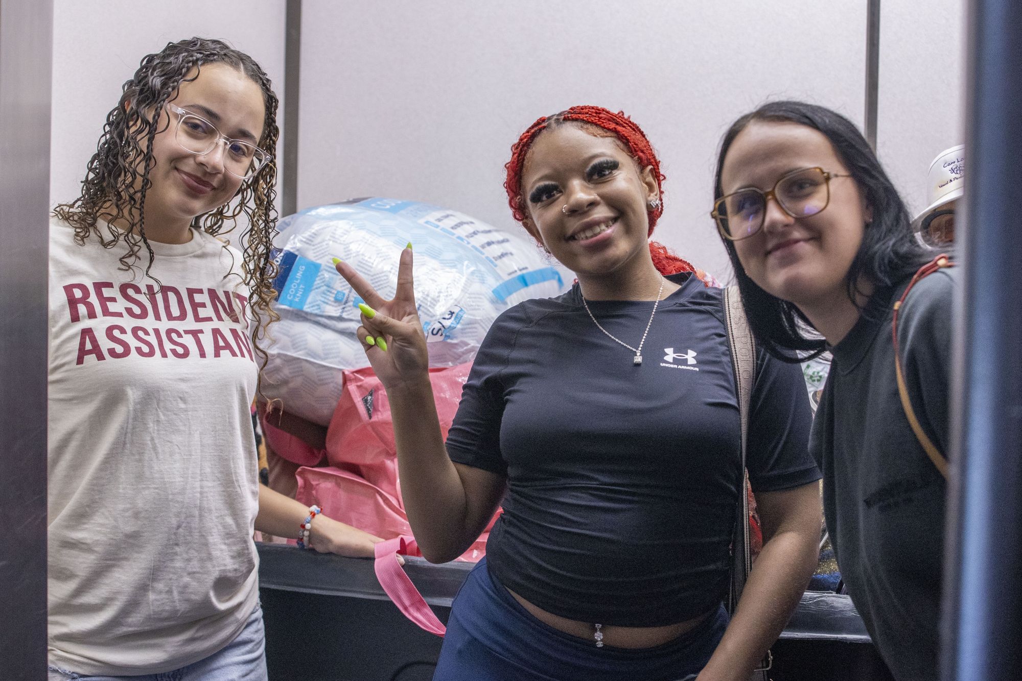 students and their RA in the elevator with their stuff on move in day