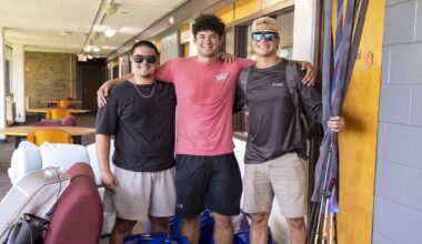 students posing for the camera outside their residence hall room on move in day