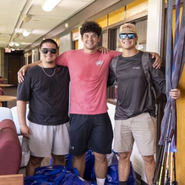 students posing for the camera outside their residence hall room on move in day