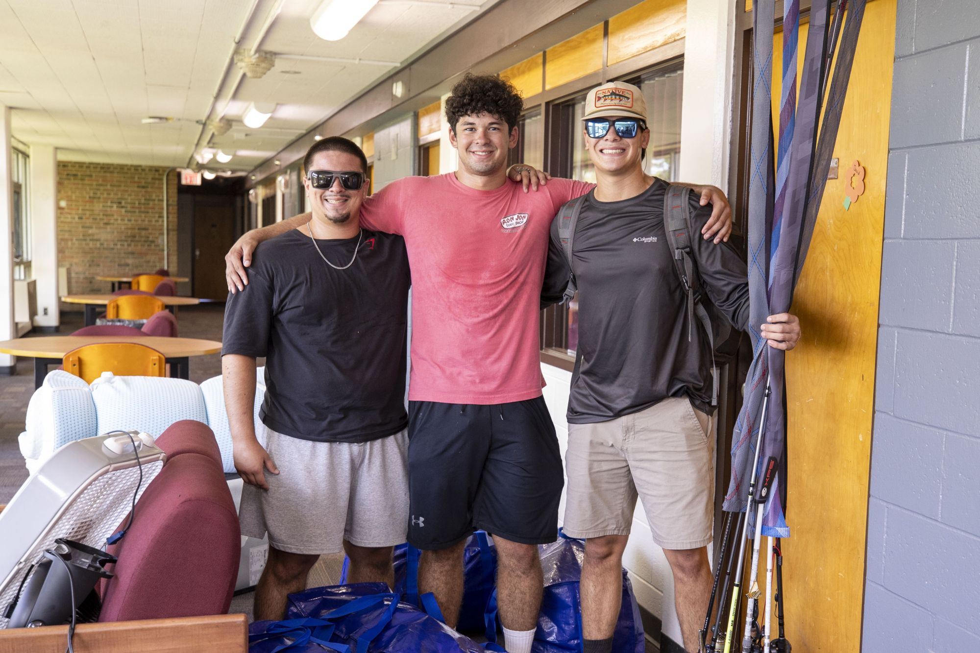 students posing for the camera outside their residence hall room on move in day