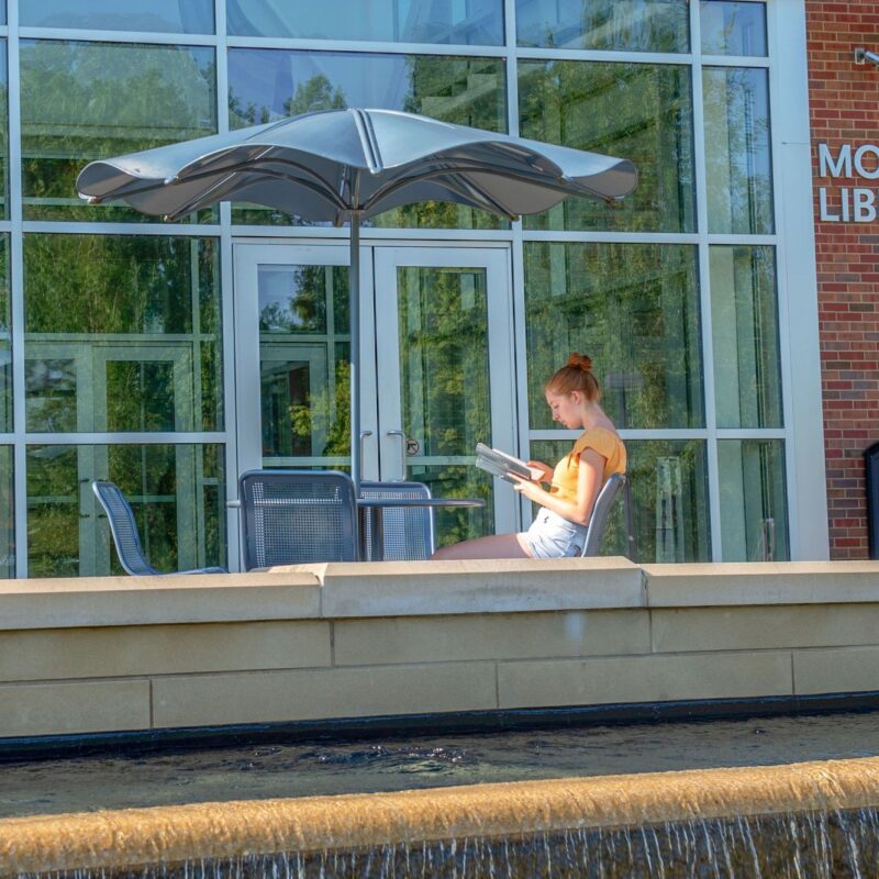 student reading outside of morris library